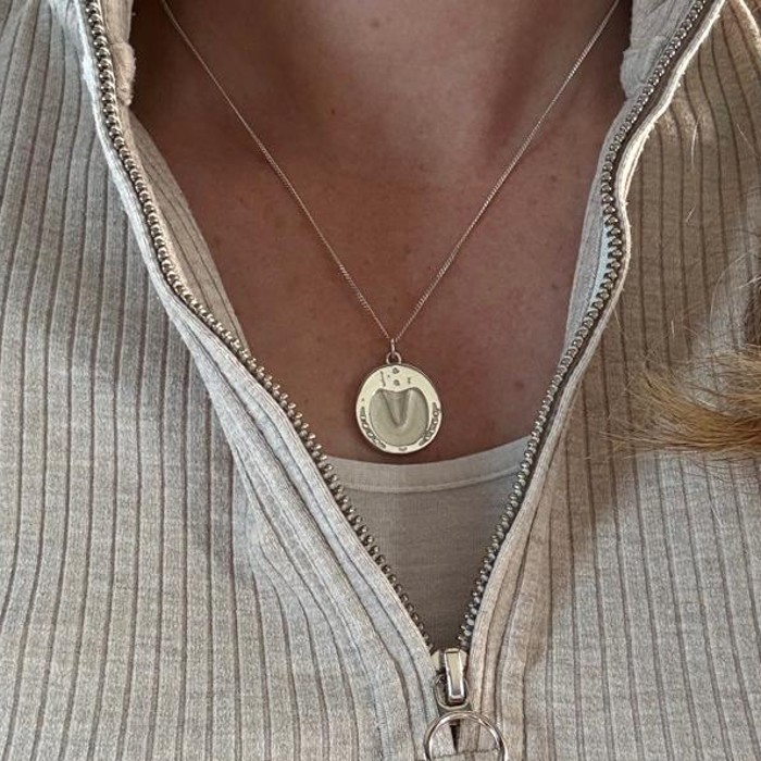 Sterling silver hoofprint pendant worn on a chain